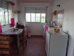 a kitchen with a white refrigerator and a sink at Lo Pituco casa de campo in Federación