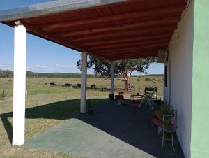 a porch of a house with a wooden pergola at Lo Pituco casa de campo in Federación