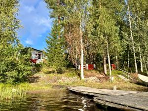 Blick auf einen See mit einem Dock und einem Haus in der Unterkunft Semi-detached cottage by the lake in Jyväskylä