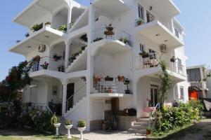 a white building with potted plants on the balconies at Apartments Armini in Ulcinj