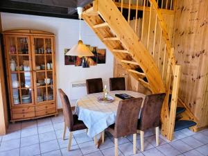 a dining room with a table and chairs and a staircase at Ferienhaus Mia im Ferienpark Extertal zwischen Teutoburger Wald und Weserbergland, Natur in Extertal