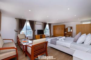 une chambre avec un lit, un canapé et une télévision dans l'établissement Villages GREEN DAY 39 View Biển TRẦN PHÚ Vũng Tàu, à Vung Tau 42 autres photos