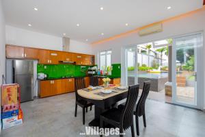 une cuisine avec une table, des chaises et des armoires vertes dans l'établissement Villages GREEN DAY 39 View Biển TRẦN PHÚ Vũng Tàu, à Vung Tau