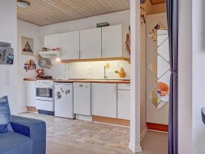 a kitchen with white cabinets and a blue couch at 4 person holiday home in Gudhjem-By Traum in Gudhjem