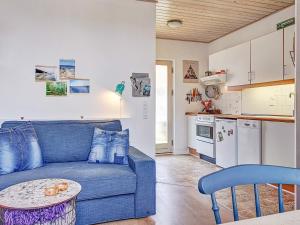 a living room with a blue couch and a kitchen at 4 person holiday home in Gudhjem-By Traum in Gudhjem