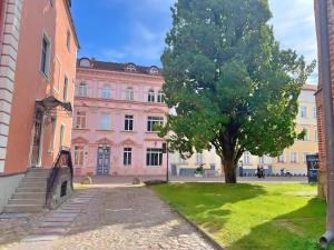 a pink building with a tree in front of it at Panda House - Luxury in Old Town in Tartu