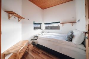 a bedroom with a large bed and two windows at Blue View Cabins in Reykholt
