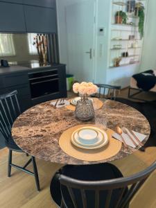a table with plates and a vase of flowers on it at Lux city apartment in Luxembourg +5 photos