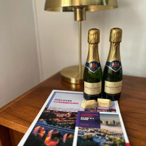 two bottles of champagne on a table with a magazine at Lux city apartment in Luxembourg