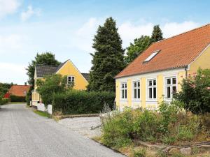 a yellow house with a red roof on a street at 6 person holiday home in Marstal in Marstal