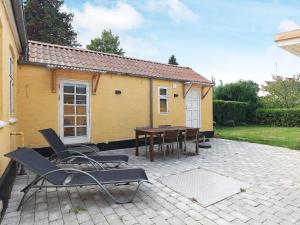 a patio with chairs and a table in front of a house at 6 person holiday home in Marstal in Marstal
