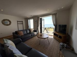 a living room with a couch and a tv at Mi Casa Su Casa - Mount Brioni in Downderry