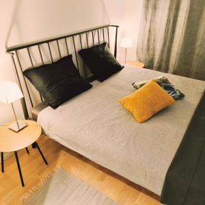 a bed with black pillows and a yellow pillow on it at Long Journey Helsinki in Helsinki