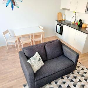 a living room with a couch and a kitchen at Long Journey Helsinki in Helsinki