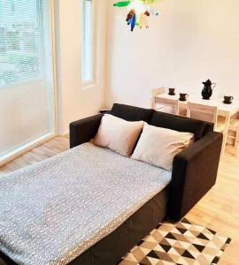 a brown couch in a living room with a table at Long Journey Helsinki in Helsinki