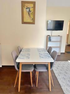a dining room table with four chairs and a television at Panda House - Luxury in Old Town in Tartu +14 photos