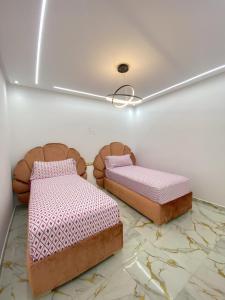 two beds sitting on a marble floor in a room at Casa almas in Chefchaouen