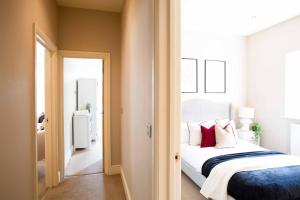 a bedroom with a white bed with red pillows at Boutique Central 2 bed In Harrogate - Sleeps 6 in Harrogate