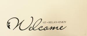 a sign that says welcome in cursive handwriting at Asteri Hotel in Livadi