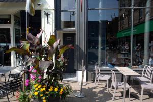 a patio with tables and chairs and flowers in front of a store at Boutique Central 2 bed In Harrogate - Sleeps 6 in Harrogate