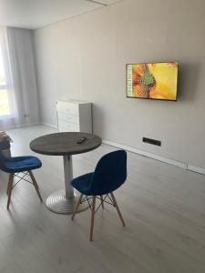 a room with a table and two blue chairs at Красивая квартира in Yuzhne