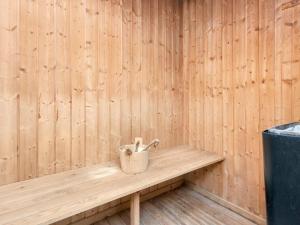 a wooden sauna with a bucket on a wooden bench at 5 star holiday home in Glesborg in Fjellerup Strand