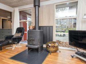a fireplace in a living room with a television at 5 star holiday home in Glesborg in Fjellerup Strand