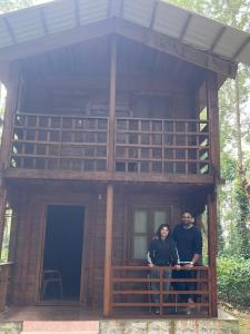 a man and woman standing in front of a tree house at Coorg Namana homestay in Suntikoppa +14 photos