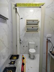 a small bathroom with a toilet and a sink at شقة فندقية غرفتين مكيفين خطوات من بوابة الجلاء الجامعة in Mansoura