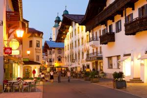 um grupo de pessoas andando por uma rua com edifícios em Alimonte Romantic Appartements em Sankt Johann in Tirol