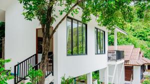 a house with black windows and a tree at Haad Yao Villa 31 in Haad Yao +4 photos