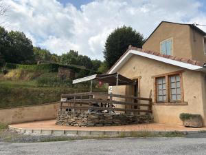 a house with a table and an umbrella at LA FORGE DU LUCIMOND in Saint-André