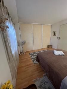 a bedroom with a bed and a wooden floor at Roissy CDG, private room 1 in Roissy-en-France