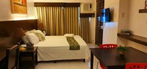 ein Schlafzimmer mit Bett und Tisch und eine Küche in der Unterkunft PRIME CITY LAND Residences Tagaytay in Iruhin + 7 Fotos