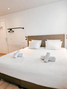 a large white bed with two white pillows on it at Alpha Hotel in Ostend +37 photos