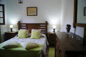 a bedroom with a bed and a desk with two lamps at Casas del Monte in Valverde