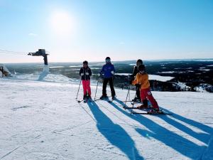 a group of people standing on top of a ski slope at RukaHillChalet5 Ski In - Ski Out - SkiPass x2 in Ruka