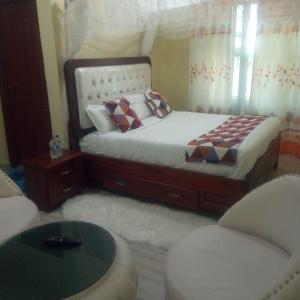 a bedroom with a bed and a table and chairs at Rodi Sweet Waters Hotel, HomaBay in Homa Bay