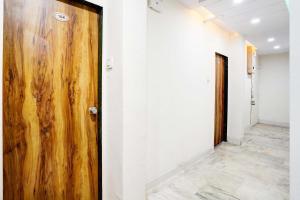 a wooden door in a room with a hallway at Hotel O Apollo in Bodakdev