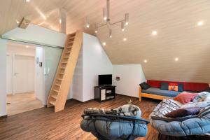 a living room with two couches and a staircase at Ferienwohnung Höfleblick in Oppenau