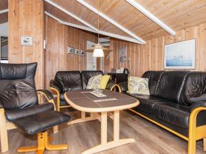 a living room with leather furniture and a table at 4 star holiday home in Rømø in Bolilmark