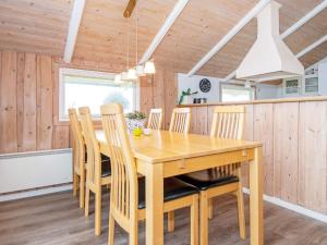 a dining room with a wooden table and chairs at 4 star holiday home in Rømø in Bolilmark