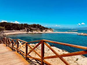 a wooden boardwalk leading to a beach next to the ocean at Can Gandaia in Viladamat