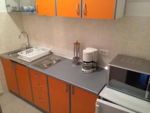 a kitchen with orange cabinets and a counter top at Apartment Maskaric in Cavtat +27 photos