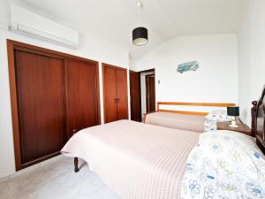 a bedroom with a bed and a wooden cabinet at Rural House in Boavista dos Pinheiros