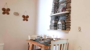 a dining room table with two chairs and a table with a butterfly decoration at Paros Heritage Retreat by ΜΡS in Parikia