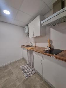 Cortez de PallasにあるRural studioの白いキャビネットと木製のカウンタートップを備えたキッチン