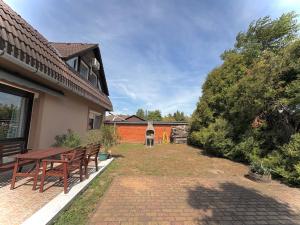 a patio with two wooden benches next to a building at Siófoki nyaralóház in Siófok