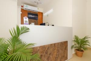 an office with two plants in front of a counter at Urban Inn Rukminigaon in Guwahati