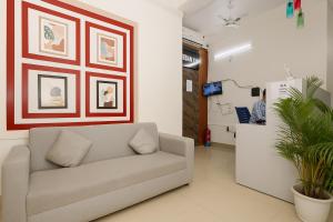 a living room with a couch and a wall at Urban Inn Rukminigaon in Guwahati +15 photos